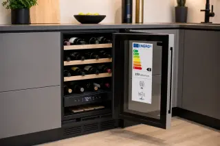 Integrated wine fridge with digital energy label and technical display, under a modern kitchen counter in natural LED light.